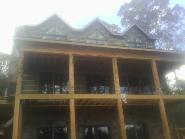 Dormers and porch framing on a large log home under construction — Roof Coating work by our crew in Northampton